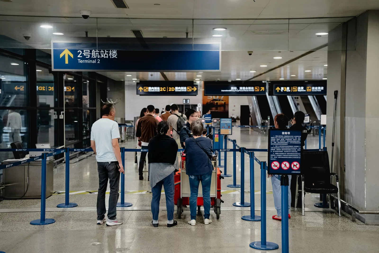 Station de taxis à la sortie d'un aéroport avec voyageurs et valises.