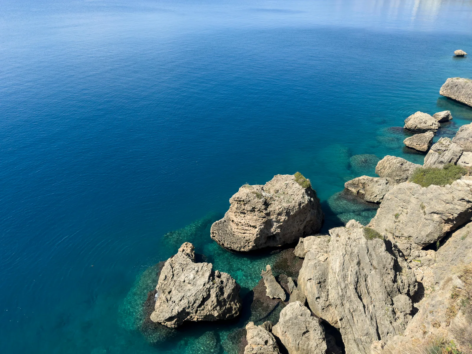Pratique de la via ferrata sur une paroi rocheuse au-dessus de la Méditerranée.