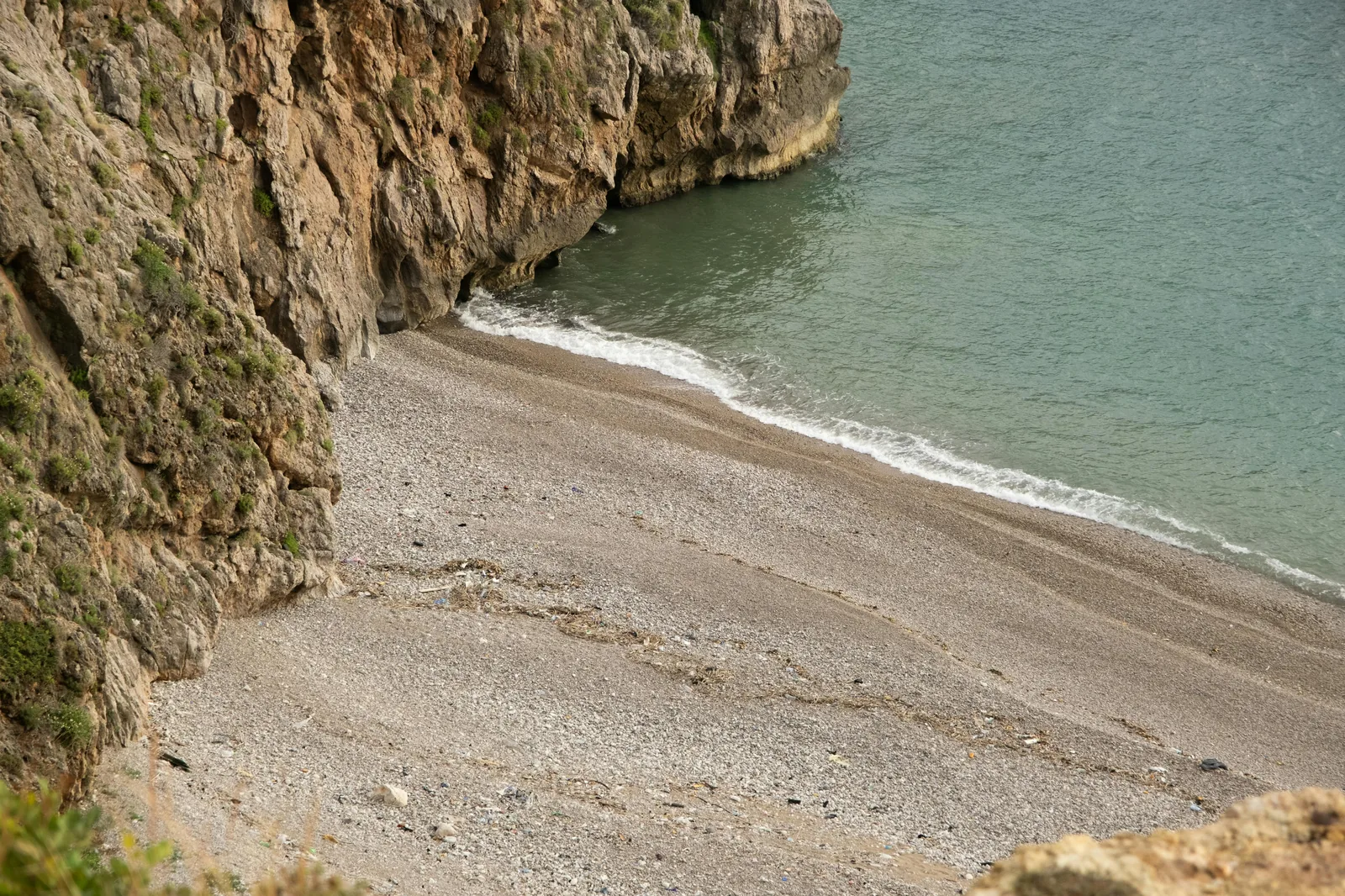 On-the-ground beach scene showing sand, water, and local architecture.