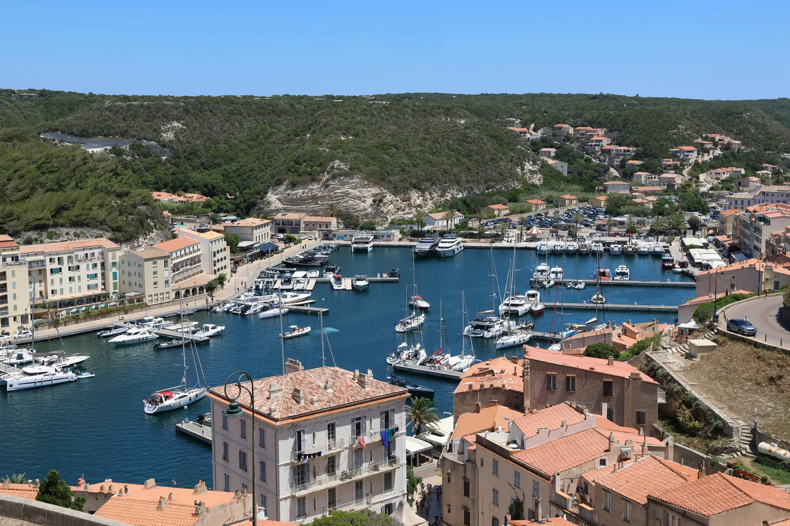 Vue large au lever du jour sur le port de Cala Figuera, avec les barques et les maisons blanches reflétées dans l'eau.