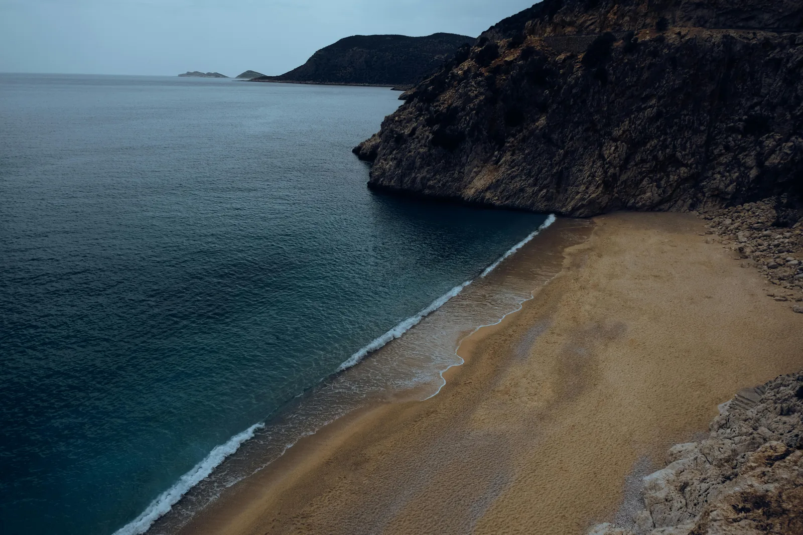 Aerial photorealistic view of Formentor beach and surrounding cliffs at golden hour.