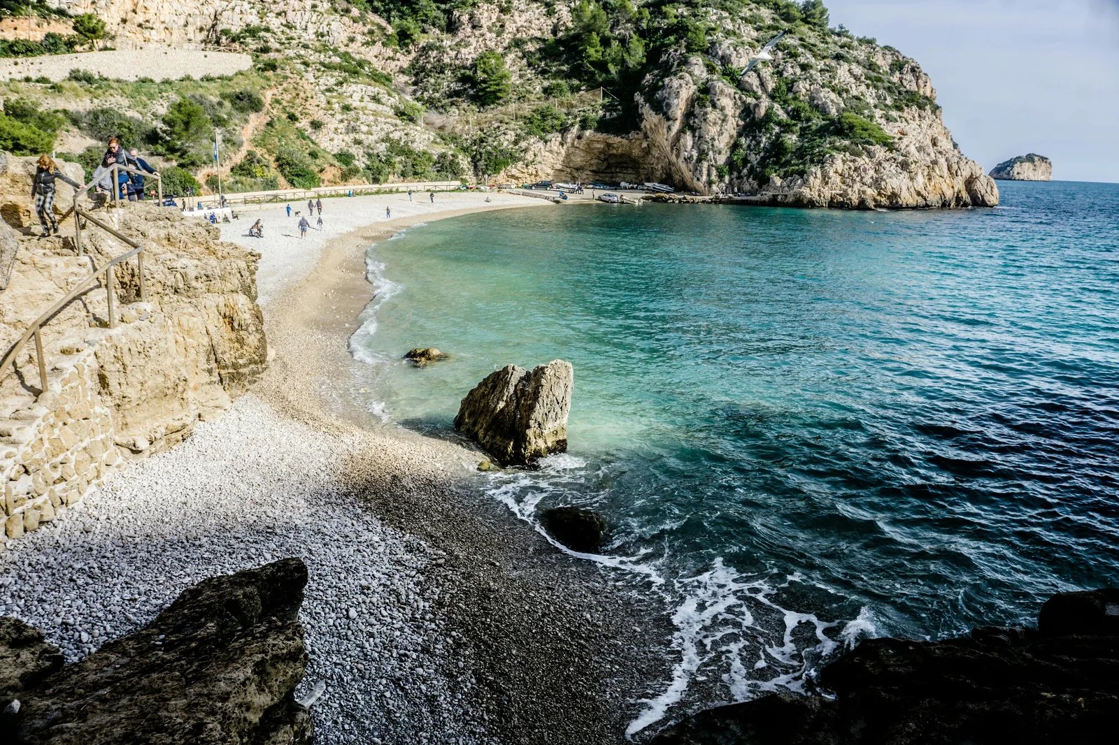 Beach-level photorealistic scene highlighting sand, water clarity, and coastal vegetation.