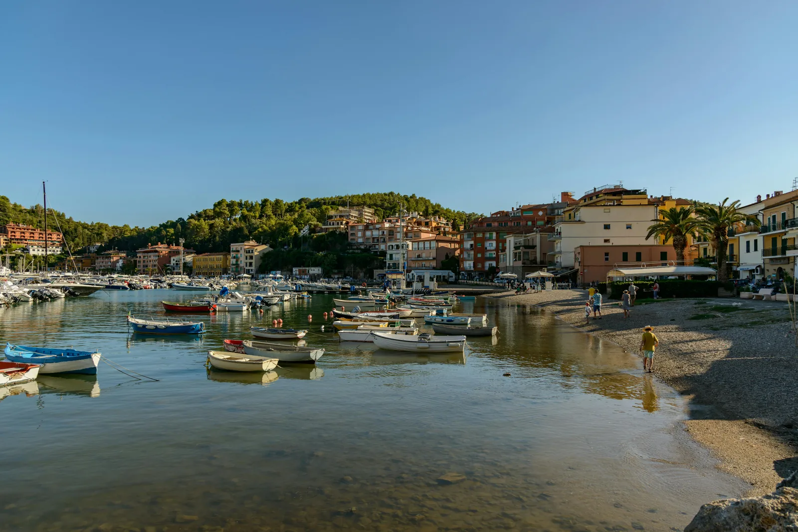 Port de Sóller promenade at golden hour with tram, beaches and mountains.