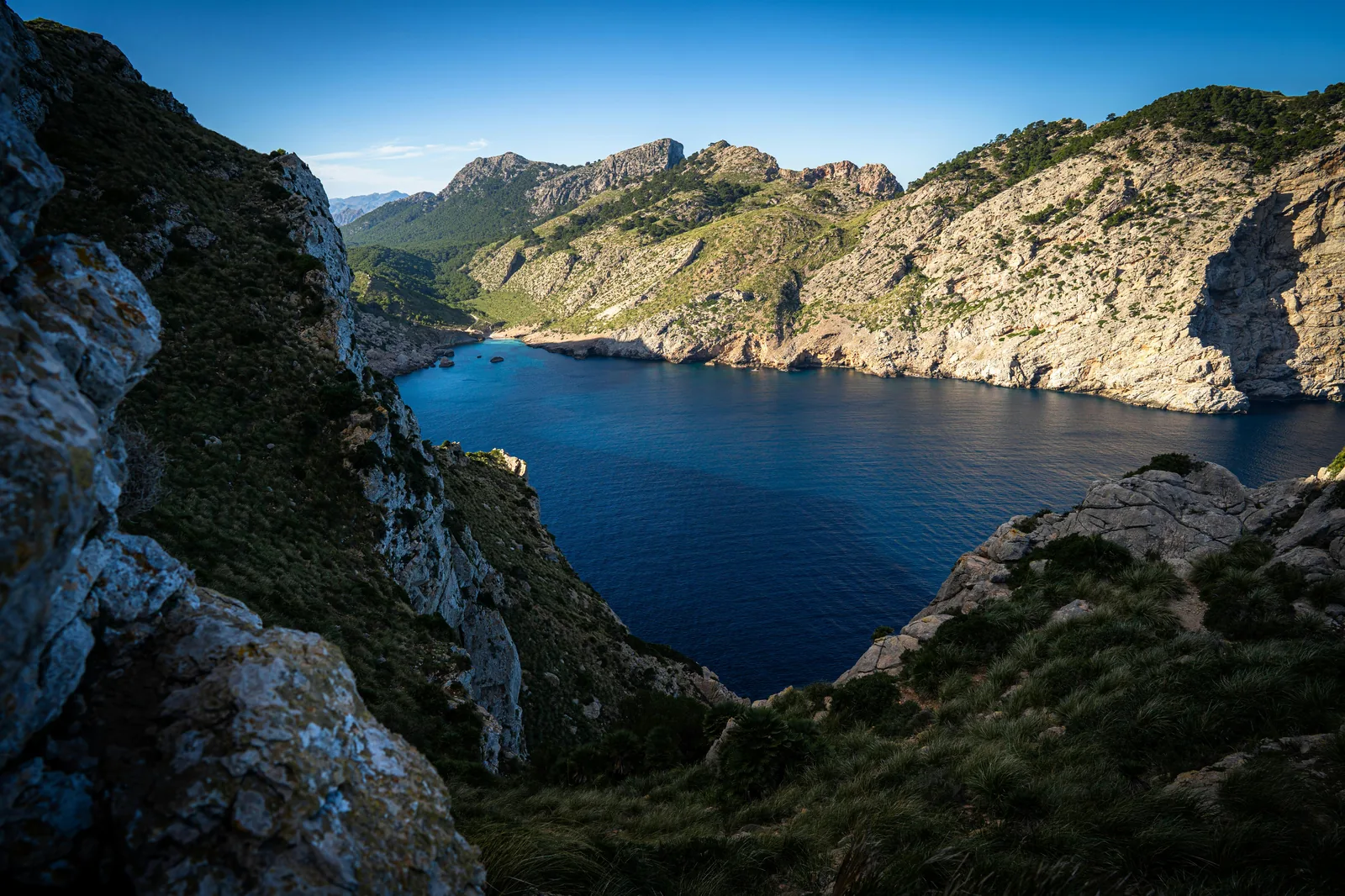 Panoramic sunrise over a secluded cove and the Serra de Tramuntana.