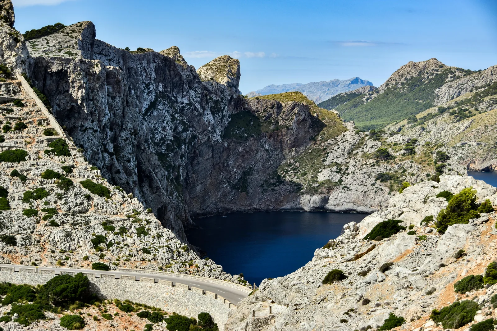 Sentier de la Serra de Tramuntana avec murs de pierre sèche et panorama sur la mer.