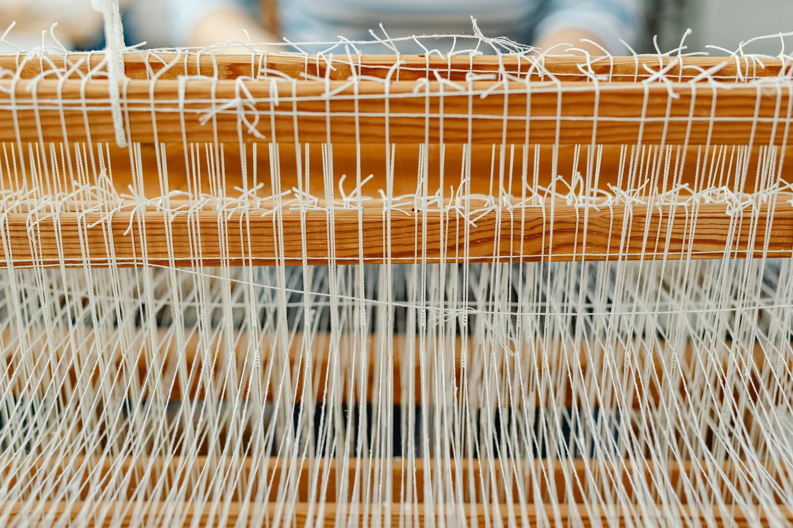 Atelier textile traditionnel : métiers à tisser en bois et tissus faits main.