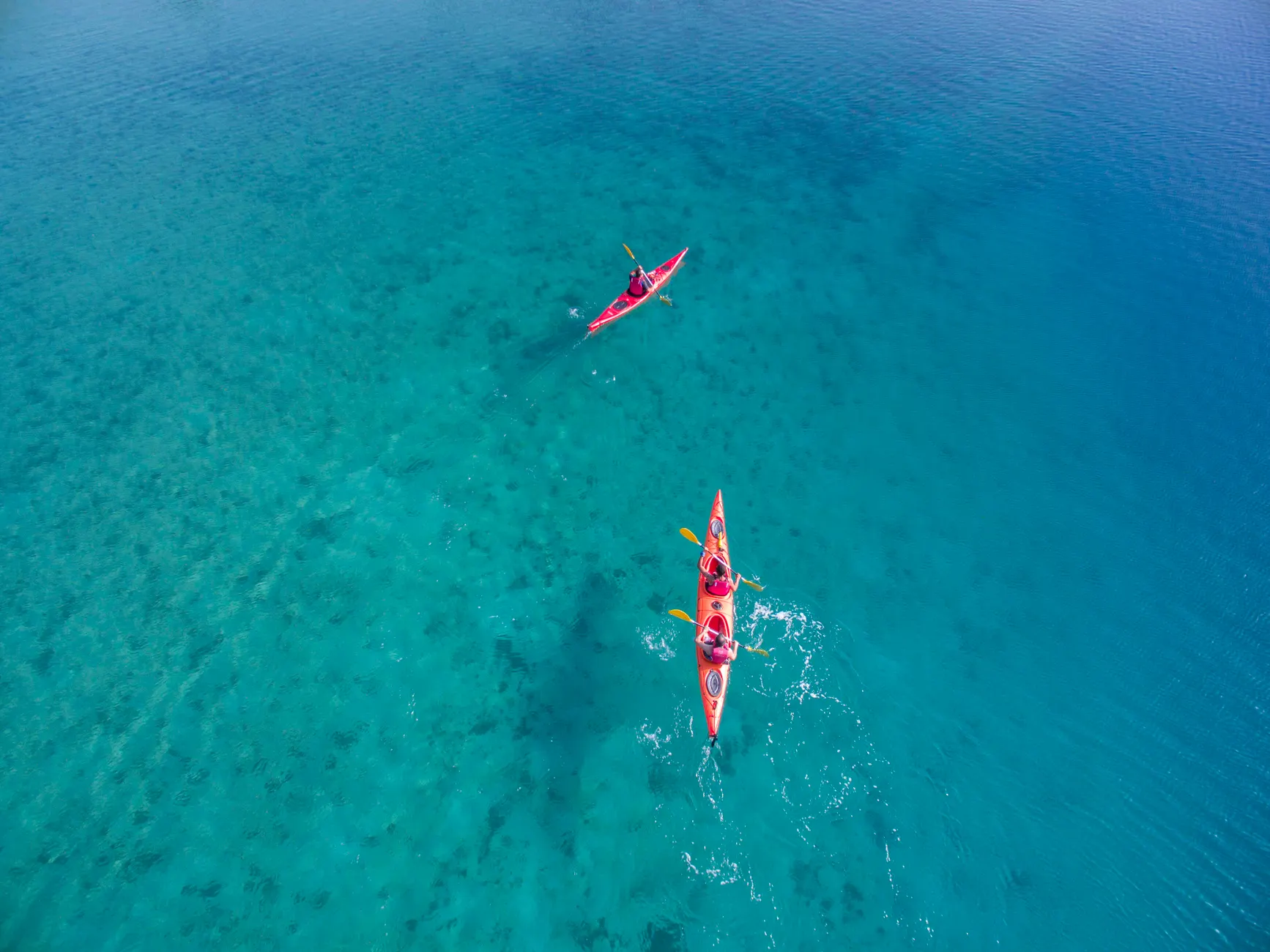 Kayakers paddle through clear turquoise waters in Ölüdeniz, Turkey. Perfect scene for adventure and travel enthusiasts.