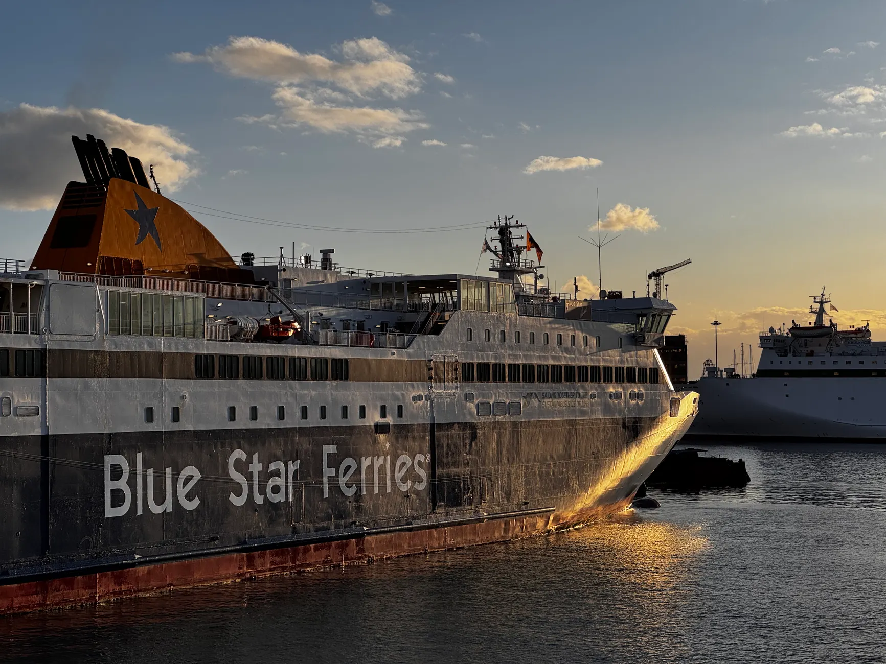 Beautiful view of a Blue Star Ferry docked in Athens, Greece at sunset, highlighting the tranquil scene.