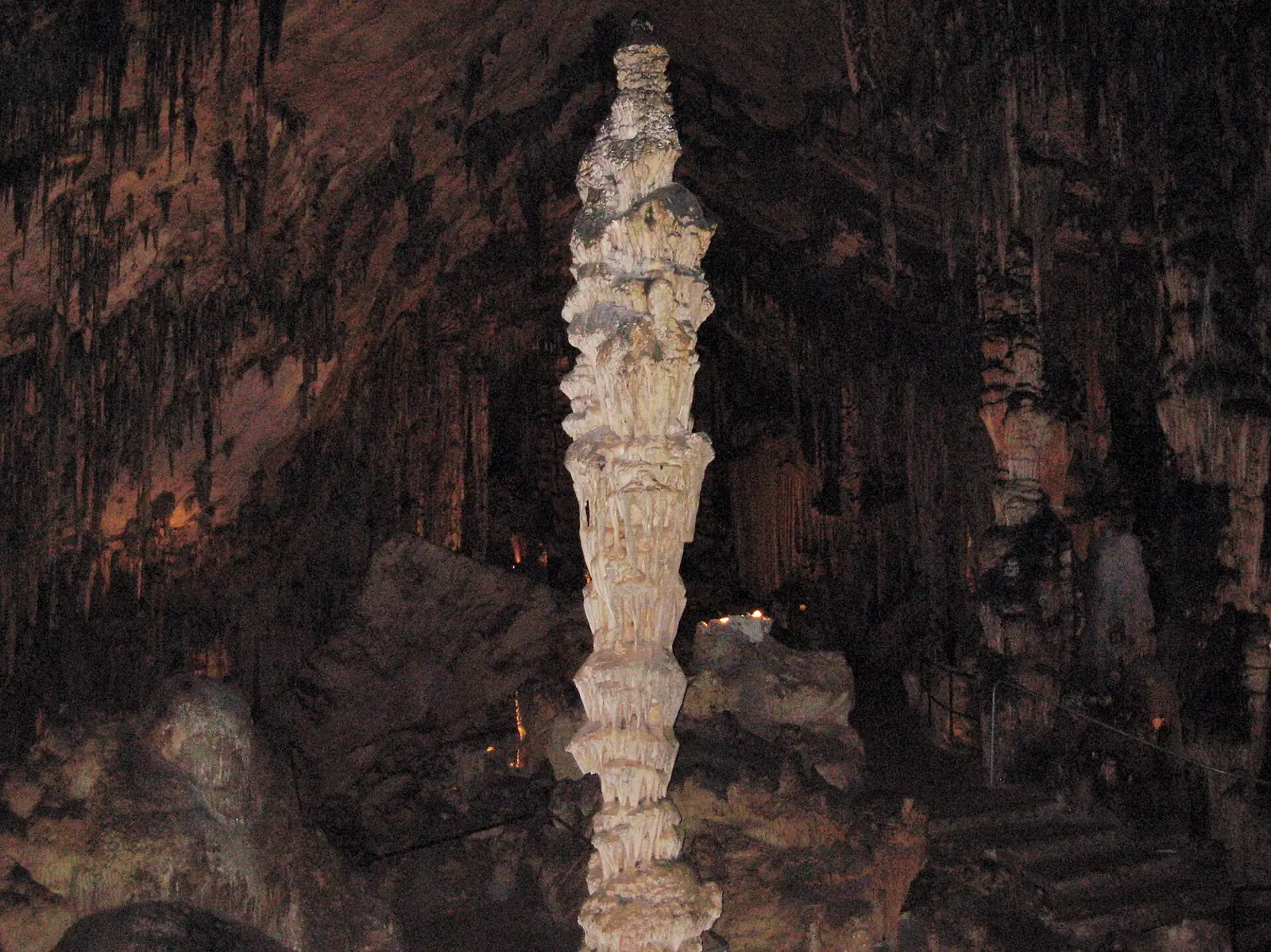 La Reine des colonnes, grande stalagmite en forme de colonne, au milieu d’une salle des grottes d’Artà, avec la rampe du parcours de visite à droite
